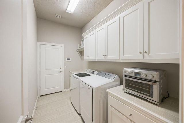 6301 Oxnard St, Edmond, OK 73034 - laundry room featuring independent washer and dryer, cabinet space, and a textured ceiling