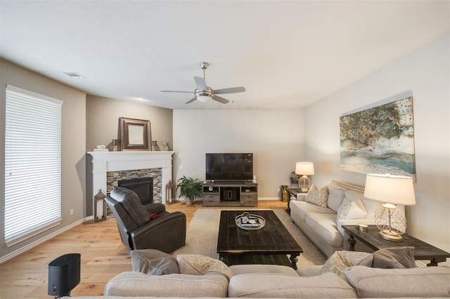 6301 Oxnard St, Edmond, OK 73034 - living area with ceiling fan, light wood-style floors, a stone fireplace, and healthy amount of natural light