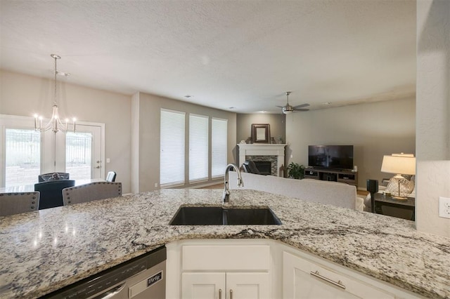6301 Oxnard St, Edmond, OK 73034 - kitchen featuring a ceiling fan, light stone counters, open floor plan, white cabinets, and a stone fireplace