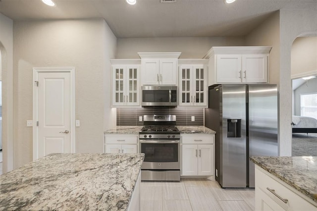 6301 Oxnard St, Edmond, OK 73034 - kitchen featuring stainless steel appliances, white cabinets, decorative backsplash, glass insert cabinets, and recessed lighting