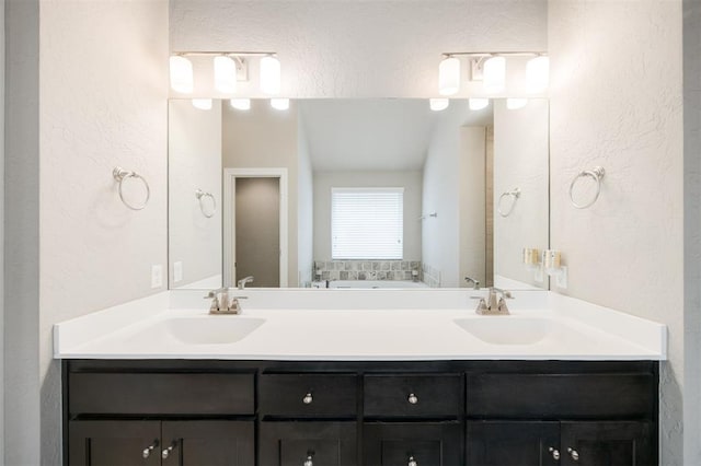6301 Oxnard St, Edmond, OK 73034 - full bathroom featuring double vanity, a garden tub, and a textured wall
