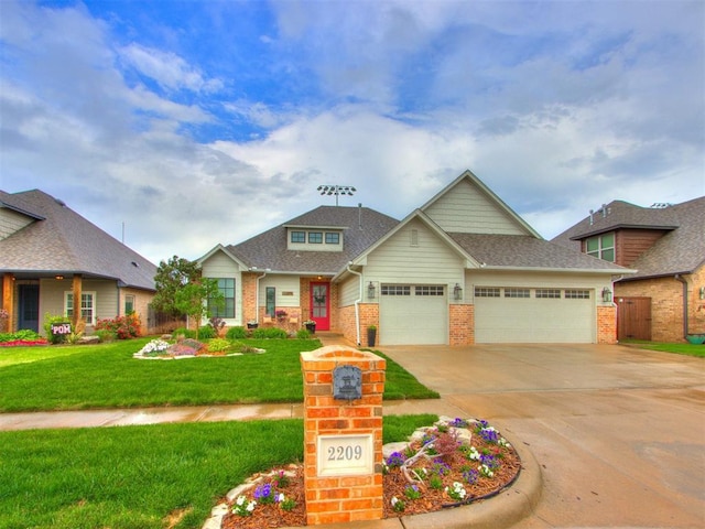 2209 Marjorie Ln, Yukon, OK 73099 - view of front of house with brick siding, a garage, driveway, and a shingled roof