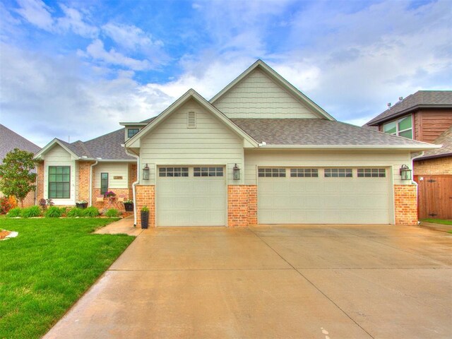 2209 Marjorie Ln, Yukon, OK 73099 - craftsman house with brick siding, an attached garage, driveway, and a shingled roof