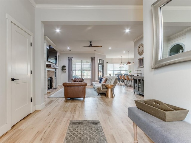 2209 Marjorie Ln, Yukon, OK 73099 - living area with crown molding, a ceiling fan, light wood finished floors, a fireplace, and recessed lighting