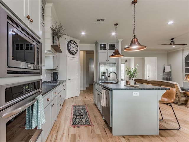 2209 Marjorie Ln, Yukon, OK 73099 - kitchen with stainless steel appliances, crown molding, a breakfast bar area, an island with sink, and ceiling fan