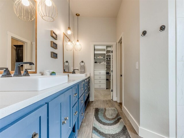 2209 Marjorie Ln, Yukon, OK 73099 - full bathroom with double vanity, wood finished floors, and a walk in closet