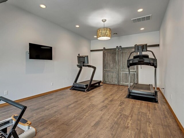 4109 Riva Ridge Ct, Edmond, OK 73003 - exercise room featuring wood finished floors, recessed lighting, and a barn door