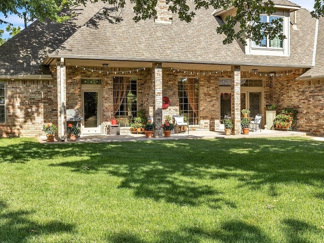 4109 Riva Ridge Ct, Edmond, OK 73003 - back of property with a patio area, brick siding, and a lawn