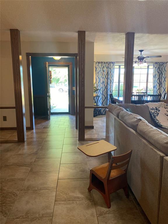 513 9th Street Cir, Hydro, OK 73048 - living room featuring a textured ceiling, healthy amount of natural light, and light tile patterned floors