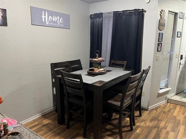dining space with wood finished floors