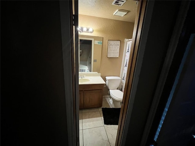 bathroom featuring vanity, tile patterned flooring, a textured wall, a textured ceiling, and a shower with curtain
