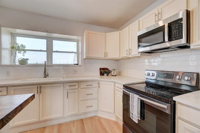 1646 County Road 1245, Tuttle, OK 73089 - kitchen with appliances with stainless steel finishes, decorative backsplash, light wood-style floors, light countertops, and white cabinets