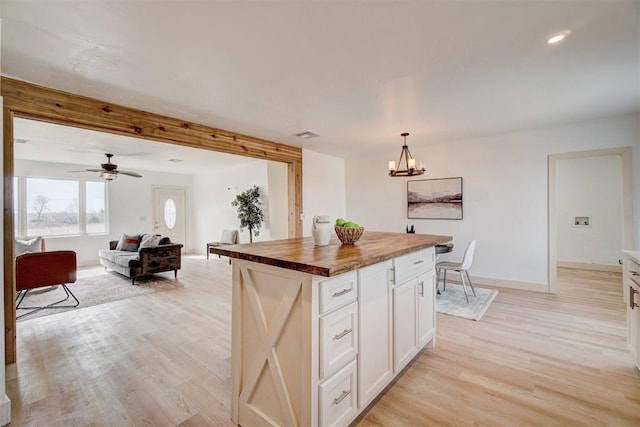 1646 County Road 1245, Tuttle, OK 73089 - kitchen with butcher block countertops, a chandelier, light wood-style floors, white cabinetry, and a kitchen island