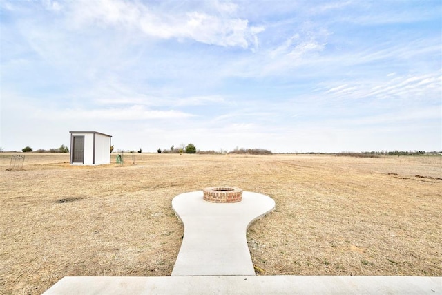 1646 County Road 1245, Tuttle, OK 73089 - view of yard featuring a fire pit, a storage shed, and a view of rural / pastoral area
