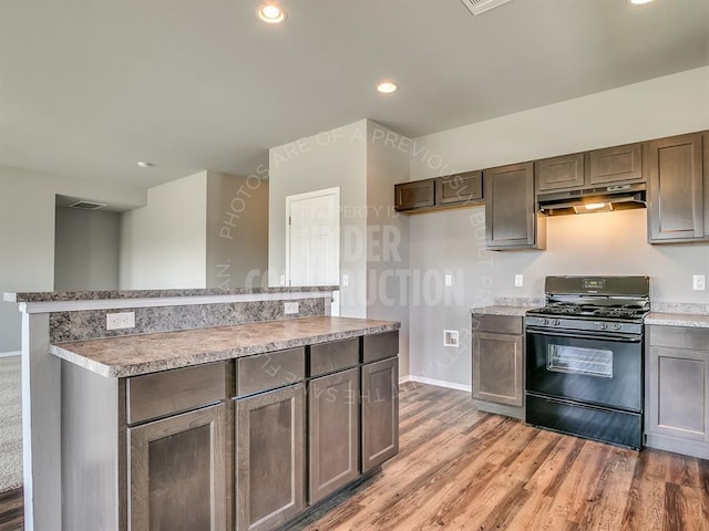 690 SW 11th St, Newcastle, OK 73065 - kitchen featuring black range with gas cooktop, under cabinet range hood, light wood-style flooring, recessed lighting, and light countertops