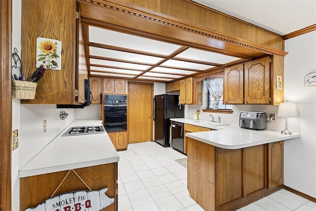 410 E Johnson St, Lexington, OK 73051 - kitchen featuring black appliances, a peninsula, light countertops, brown cabinetry, and a warming drawer
