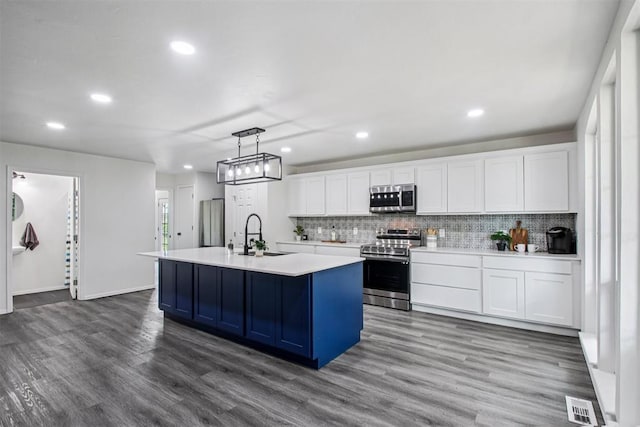 1600 Silver Stone Rd, Blanchard, OK 73010 - kitchen featuring appliances with stainless steel finishes, white cabinetry, dark wood-type flooring, tasteful backsplash, and recessed lighting
