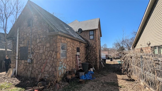 121 N High Ave, Shawnee, OK 74801 - view of side of property featuring stone siding and a shingled roof