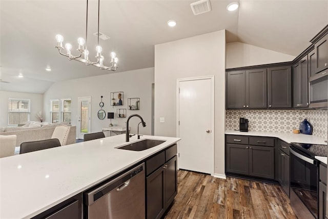 8705 Gibbs Dr, Oklahoma City, OK 73135 - kitchen with appliances with stainless steel finishes, lofted ceiling, backsplash, light countertops, and dark wood-style flooring