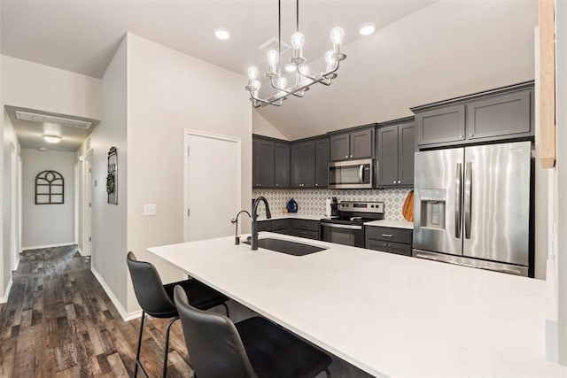 8705 Gibbs Dr, Oklahoma City, OK 73135 - kitchen featuring appliances with stainless steel finishes, dark wood-style floors, backsplash, lofted ceiling, and light countertops
