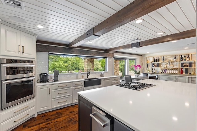 2800 E 15th St, Edmond, OK 73013 - kitchen featuring stainless steel appliances, dark wood-type flooring, light countertops, recessed lighting, and white cabinetry