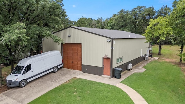 2800 E 15th St, Edmond, OK 73013 - view of home's exterior featuring a detached garage, a lawn, an outdoor structure, view of scattered trees, and concrete driveway
