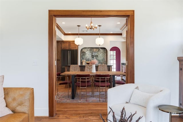 814 NE 18th St, Oklahoma City, OK 73105 - dining space with arched walkways, light wood-style flooring, a chandelier, and crown molding