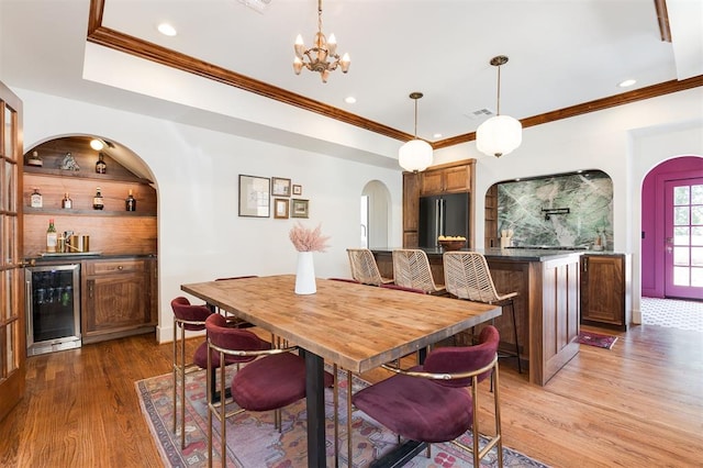 814 NE 18th St, Oklahoma City, OK 73105 - dining room with wine cooler, arched walkways, a dry bar, wood finished floors, and crown molding