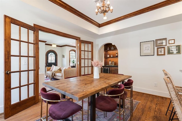814 NE 18th St, Oklahoma City, OK 73105 - dining room featuring crown molding, a chandelier, arched walkways, light wood-style floors, and french doors