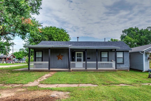 201 E 2nd St, Stroud, OK 74079 - view of front of home with covered porch, a front lawn, board and batten siding, and roof with shingles