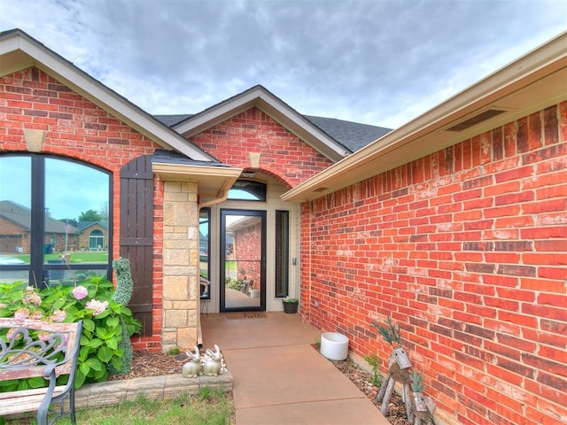 2724 SE 97th St, Oklahoma City, OK 73160 - doorway to property featuring brick siding and a shingled roof