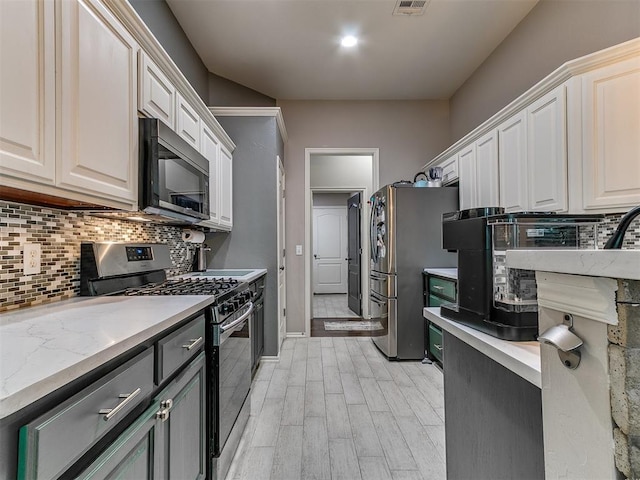 2724 SE 97th St, Oklahoma City, OK 73160 - kitchen featuring stainless steel appliances, backsplash, white cabinets, and light wood-style floors