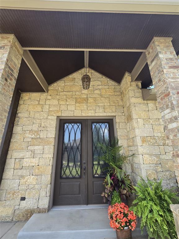 9252 Elaine Dr, Midwest City, OK 73130 - property entrance with french doors and stone siding