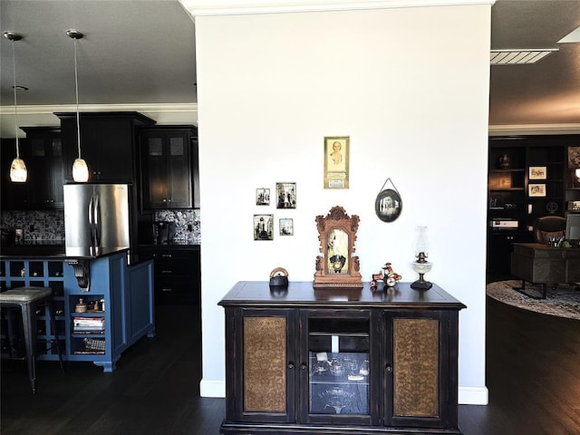9252 Elaine Dr, Midwest City, OK 73130 - bar with freestanding refrigerator, dark wood-style flooring, backsplash, and hanging light fixtures