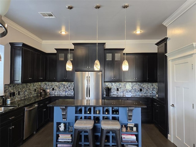 9252 Elaine Dr, Midwest City, OK 73130 - kitchen with appliances with stainless steel finishes, a kitchen island, dark stone counters, a kitchen breakfast bar, and hanging light fixtures