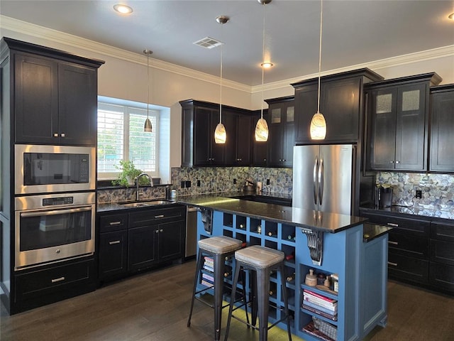 9252 Elaine Dr, Midwest City, OK 73130 - kitchen with stainless steel appliances, a kitchen island, a kitchen bar, decorative backsplash, and glass insert cabinets