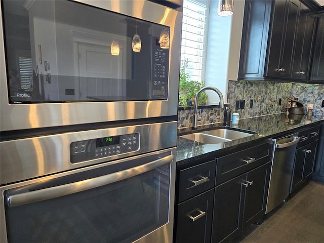 9252 Elaine Dr, Midwest City, OK 73130 - kitchen featuring appliances with stainless steel finishes, dark cabinetry, dark stone counters, and decorative backsplash