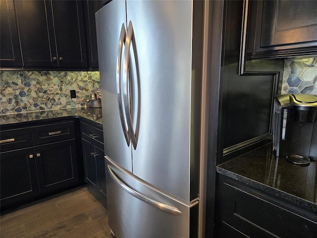 9252 Elaine Dr, Midwest City, OK 73130 - kitchen with freestanding refrigerator, tasteful backsplash, dark wood-style floors, dark cabinetry, and dark stone countertops