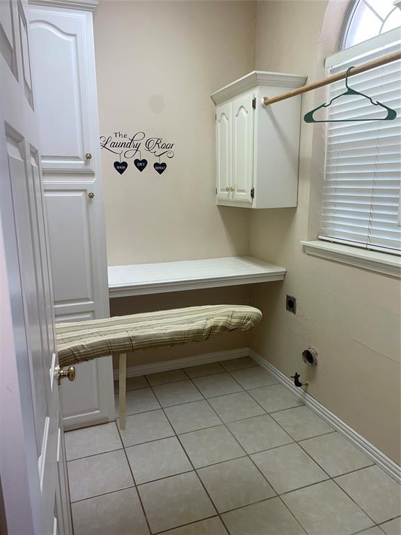 5725 SE 86th St, Oklahoma City, OK 73135 - laundry room featuring hookup for an electric dryer, gas dryer hookup, cabinet space, and light tile patterned floors