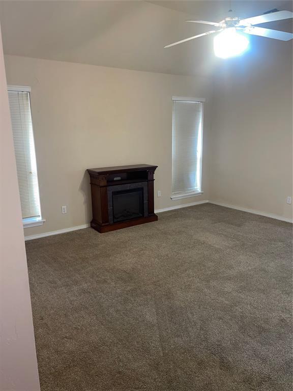 5725 SE 86th St, Oklahoma City, OK 73135 - unfurnished living room with carpet, ceiling fan, and a fireplace