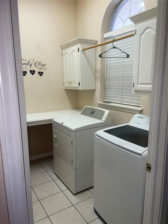 5725 SE 86th St, Oklahoma City, OK 73135 - washroom with washer and clothes dryer, cabinet space, and light tile patterned floors