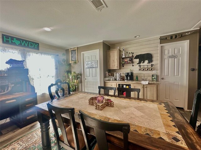 420 N College St, Cordell, OK 73632 - dining room featuring a bar, wood finished floors, a textured ceiling, ornamental molding, and recessed lighting