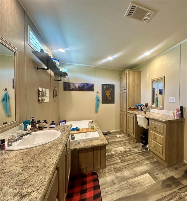 420 N College St, Cordell, OK 73632 - bathroom with wood finished floors, two vanities, and a tub