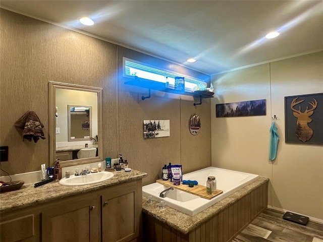420 N College St, Cordell, OK 73632 - bathroom featuring a garden tub, vanity, wood finished floors, and recessed lighting