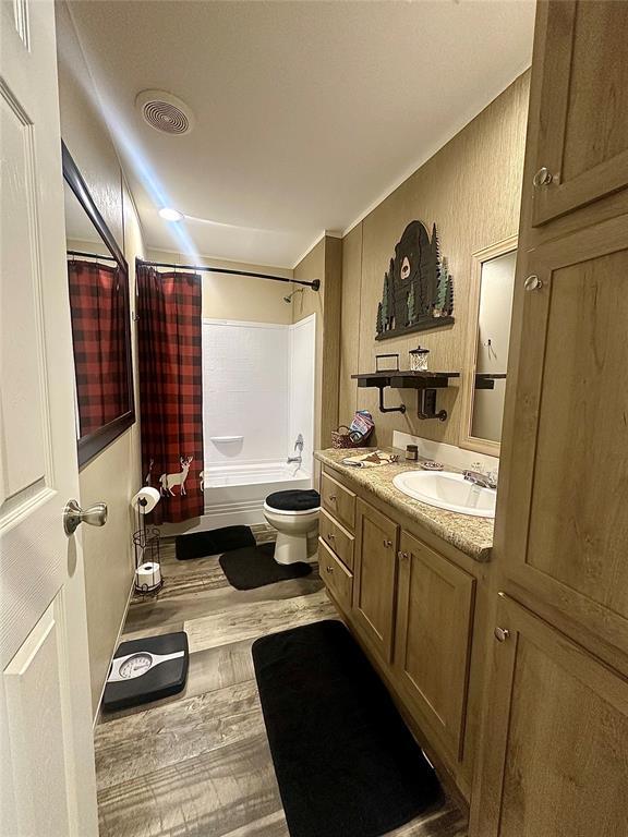 420 N College St, Cordell, OK 73632 - bathroom with vanity, shower / bath combo, and wood finished floors