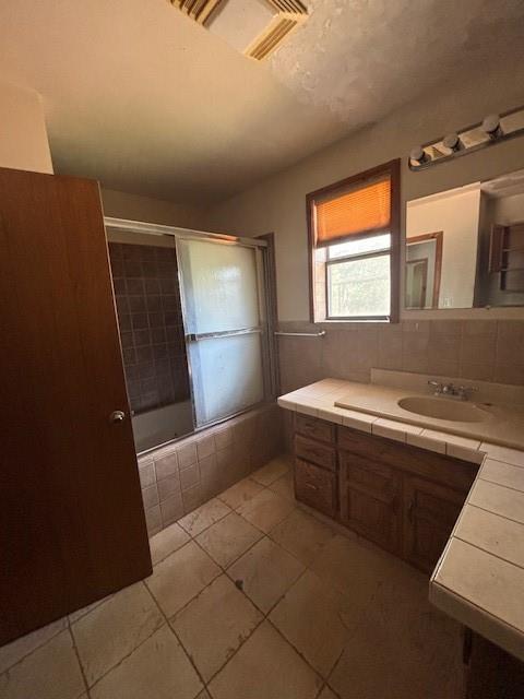 11825 N 3660th Rd, Cromwell, OK 74884 - bathroom with vanity, tile patterned floors, tiled shower / bath combo, and tile walls