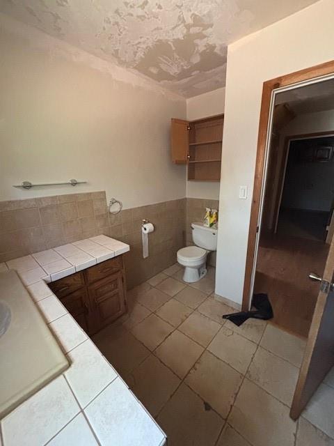 11825 N 3660th Rd, Cromwell, OK 74884 - bathroom with tile walls, tile patterned floors, wainscoting, and vanity