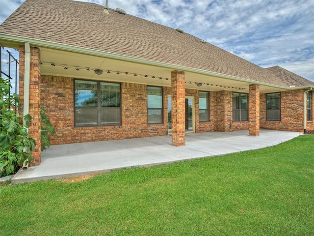 3004 Twin Lake Dr, Moore, OK 73165 - rear view of house with roof with shingles, a yard, a patio, and brick siding