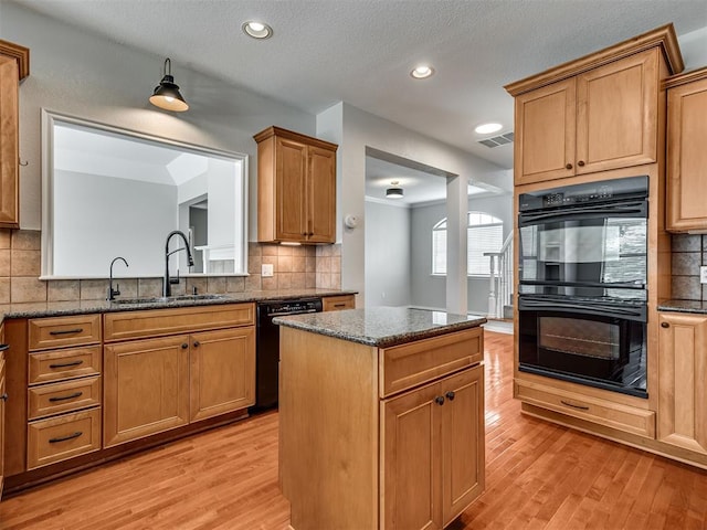 3004 Twin Lake Dr, Moore, OK 73165 - kitchen featuring black appliances, decorative backsplash, light wood-style floors, a kitchen island, and recessed lighting