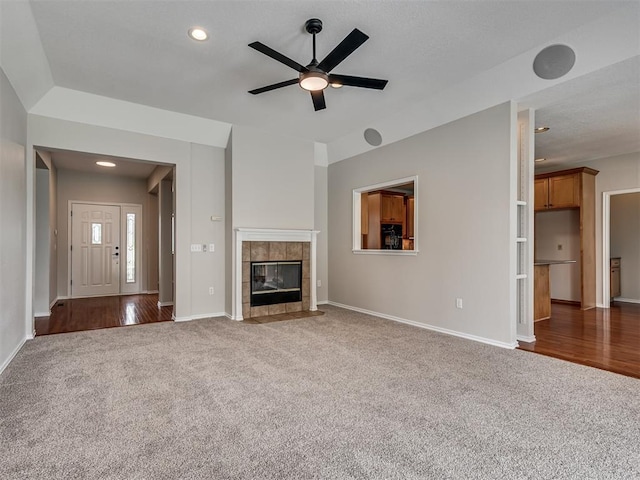3004 Twin Lake Dr, Moore, OK 73165 - unfurnished living room featuring carpet flooring, ceiling fan, a tiled fireplace, recessed lighting, and wood finished floors